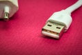 New USB charger cable on red surface closeup often used for charging smartphone or tablet Royalty Free Stock Photo