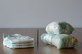 New and used baby diapers on the wooden table background. Royalty Free Stock Photo