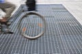 New ventilation iron grid in an urban area with a cyclist passing Royalty Free Stock Photo