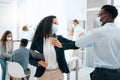 A new way of greeting. two young businesspeople greeting each other with an elbow bump at work. Royalty Free Stock Photo