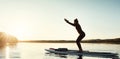The new way to do yoga. an attractive young woman doing yoga on a paddle board on a lake outdoors. Royalty Free Stock Photo