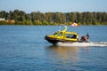 At the New Westminster Quay, a yellow taxi ferry speed boat travels from quay pier to Queensbourgh with a Canadian flag