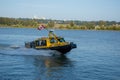 At the New Westminster Quay, a yellow taxi ferry speed boat travels from quay pier to Queensbourgh with a Canadian flag