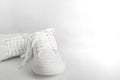 New white female or teen sneakers isolated on white background. White textile sneakers with rubber soles with tied laces on a