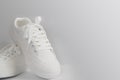 New white female or teen sneakers isolated on white background. White textile sneakers with rubber soles with tied laces on a