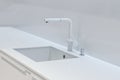 A new white kitchen sink made of artificial stone and a faucet. The concept of modern kitchen interior Royalty Free Stock Photo