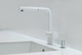 A new white kitchen sink made of artificial stone and a faucet. The concept of modern kitchen interior Royalty Free Stock Photo