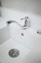 A new white kitchen sink made of artificial stone and a faucet. The concept of modern kitchen interior. Vertical photography Royalty Free Stock Photo