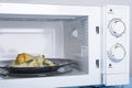 White microwave oven, on a blue wooden surface for heating food Royalty Free Stock Photo