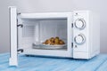 White microwave oven, on a blue wooden surface for heating food Royalty Free Stock Photo