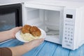 White microwave oven, on a blue wooden surface for heating food Royalty Free Stock Photo