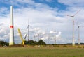 new wind turbine is erected in a wind farm with the help of a large yellow crane Royalty Free Stock Photo