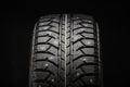 New winter studded tire close-up on a black background, front view Royalty Free Stock Photo