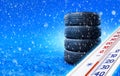 New winter tires stacked on the snow road and thermometer showing negative temperature.