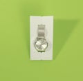 New women`s wrist watch no name, silver look with an iron bracelet on a stand. On a green background. Copy space Royalty Free Stock Photo