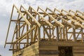 New wooden ecological house from natural materials under construction. Close-up detail of attic roof frame against clear sky. Royalty Free Stock Photo