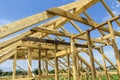 New wooden ecological house from natural materials under construction. Close-up detail of attic roof frame against clear sky from Royalty Free Stock Photo