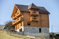 New wooden ecological traditional cottage house of natural lumber materials with shingle roof and stone basement under