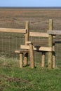 New wooden stile over wire fence in countryside