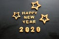 2020 new year background. Baked letters Happy New year and numbers 2020, stars, snowflakes on a black background Royalty Free Stock Photo