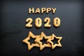 2020 new year background. Baked letters Happy New year and numbers 2020, stars, snowflakes on a black background Royalty Free Stock Photo