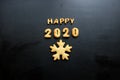 2020 new year background. Baked letters Happy New year and numbers 2020, stars, snowflakes on a black background Royalty Free Stock Photo