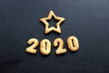 2020 new year background. Baked letters Happy New year and numbers 2020, stars, snowflakes on a black background Royalty Free Stock Photo