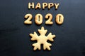 2020 new year background. Baked letters Happy New year and numbers 2020, stars, snowflakes on a black background Royalty Free Stock Photo