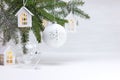 New year background with christmas tree branch, wooden decorative toy houses garland and glass balls Royalty Free Stock Photo