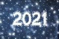 2021 new year background concept - white numbers decorated with snowflakes and snow on blue blurred background with snowflakes