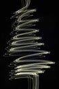 New Year backgroundAbstract Christmas tree shape created with golden light trails on a deep black background. Royalty Free Stock Photo
