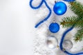 New Year banner with blue and silver Christmas balls in snow, spruce green branches on white background. Xmas decoration Royalty Free Stock Photo