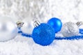 New Year banner with blue, silver and white Christmas balls in snow on abstract winter background. Royalty Free Stock Photo