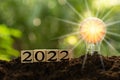 The new year 2022 and bright light bulb on the mound. Concept of a startup that drives the economy, finance, banking, forward,