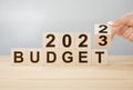 New year business plan concept in 2023. Male hand flips wooden cube and changes the inscription BUDGET 2022 to BUDGET 2023, copy Royalty Free Stock Photo