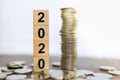 2020 New year, Business, Saving and Planning Concept. Close up of stack of wooden number block toy with stack of coins on wood Royalty Free Stock Photo