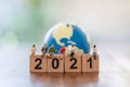 2021 New year Business Team concept. Group of businessman and businesswoman miniature figure people sitting on wooden number block Royalty Free Stock Photo