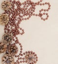 Cones and brown beads on a parchment background. Royalty Free Stock Photo