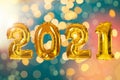 2021 New Year celebration. Gold balloons and blurred lights on color background Royalty Free Stock Photo