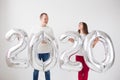 New year, celebration and holidays concept - love couple having fun with sign 2020 made of silver balloons for new year Royalty Free Stock Photo