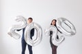 New year, celebration and holidays concept - love couple having fun with sign 2020 made of silver balloons for new year Royalty Free Stock Photo