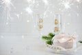 New Year Celebration. Silver Christmas table setting with two champagne glasses on the dinner table and gift box. Royalty Free Stock Photo