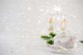 New Year Celebration. Silver Christmas table setting with two champagne glasses on the dinner table and gift box. Royalty Free Stock Photo