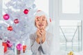 Portrait of happy preteen boy in red Santa Claus hat looking through heart of Christmas candy canes, holding sweets in Royalty Free Stock Photo