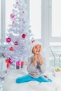 Portrait of happy preteen boy in red Santa Claus hat looking through heart of Christmas candy canes, holding sweets in Royalty Free Stock Photo