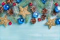 New Year or Christmas background: fir branches, colorful glass balls, cones and golden stars over blue painted wooden Royalty Free Stock Photo