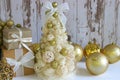 New Year, Christmas background, rustic style. Festive Christmas tree in gold on white wood background and craft boxes tied with sa