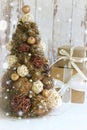 New Year, Christmas background, rustic style. Festive Christmas tree in gold on white wood background and craft boxes tied with sa
