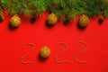 New Year 2022. Christmas banner made of fir branches with cones and balls on a red background. Beads lettering numbers Royalty Free Stock Photo