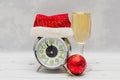 New Year or Christmas card - an alarm clock in a Santa Claus hat and wine. New Year and Christmas concept Royalty Free Stock Photo